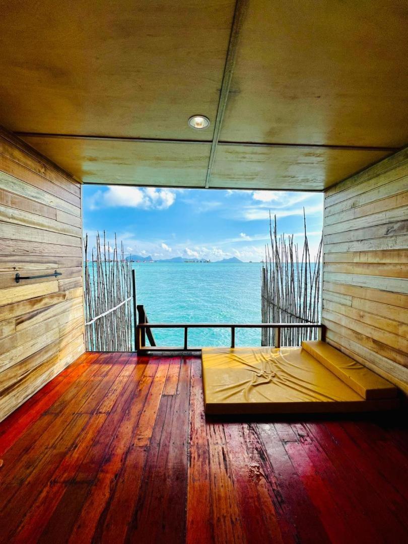 Close-up of direct wooden access stairs plunging into vibrant crystal-clear water at Nusakuya Resort.
