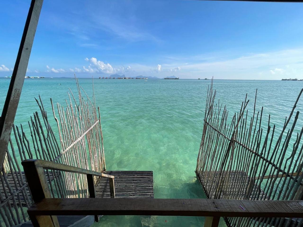 Private oceanview balcony with sun loungers and direct stair access to the sea at Nusakuya Resort.